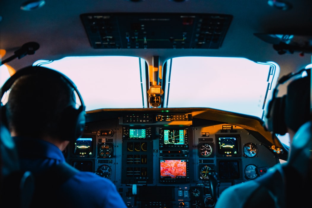 A back view of two pilots inside a cockpit